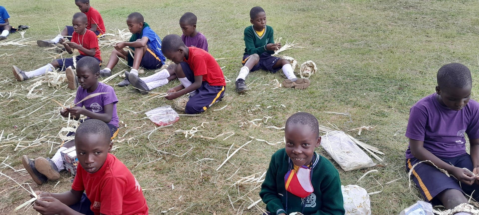 Learners weaving baskets from palm leaves on craft day