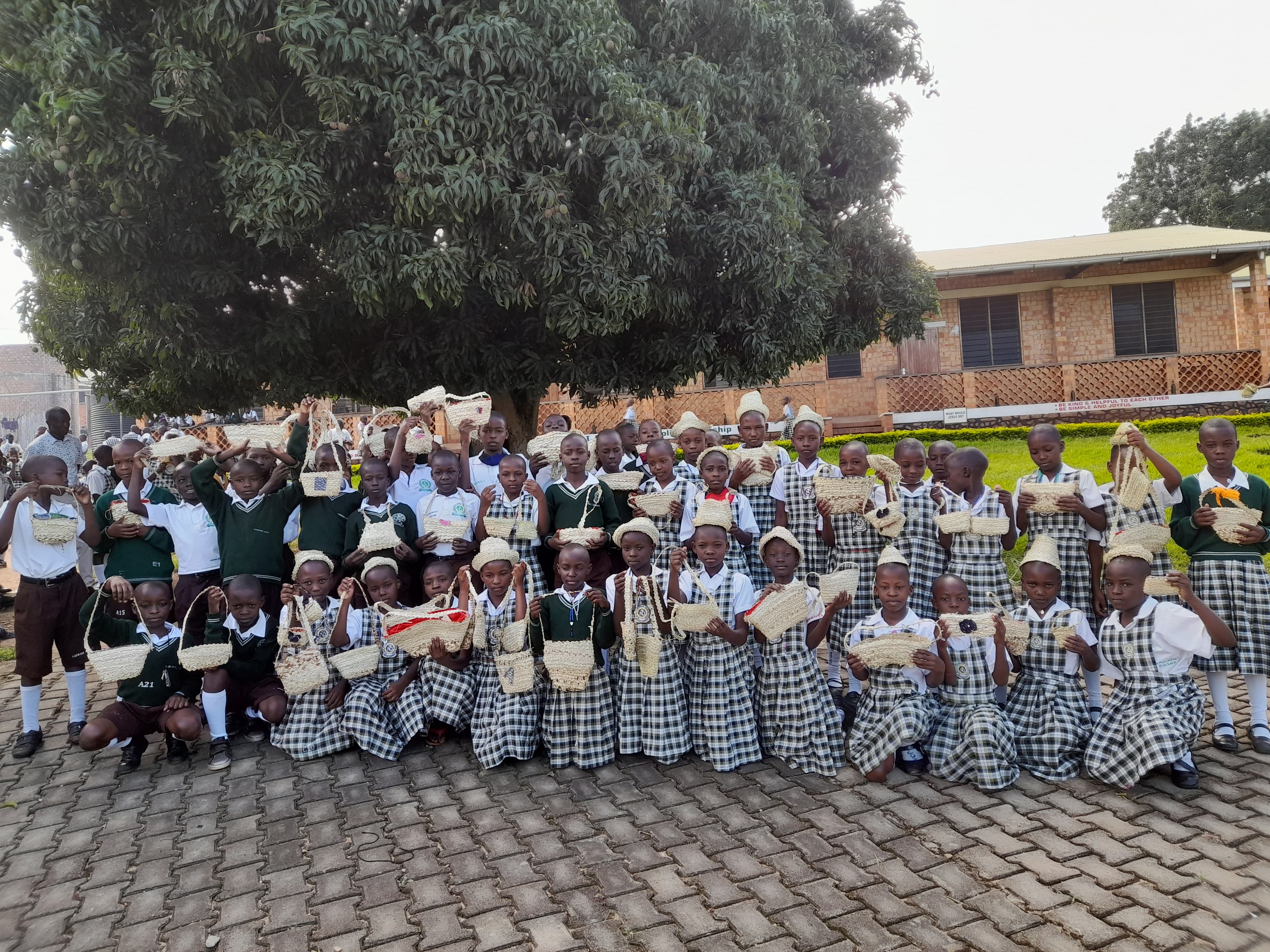 Learners showing off handwoven baskets they made on campus