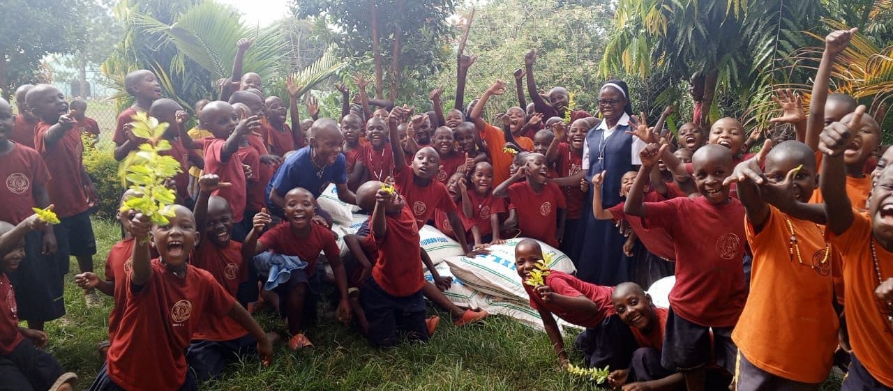 A Sister of Notre Dame with learners celebrating donated food supplies